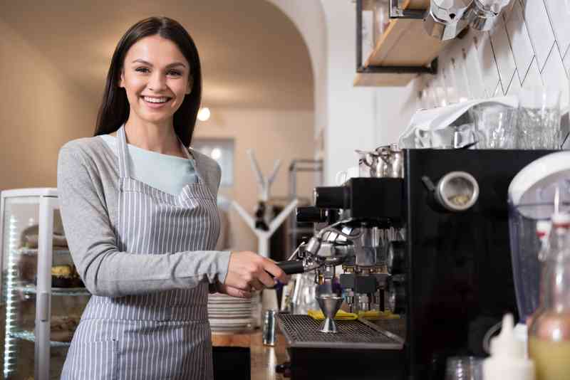 Putting into service. Девочка с кофемашиной. Pretty Barista smiling.